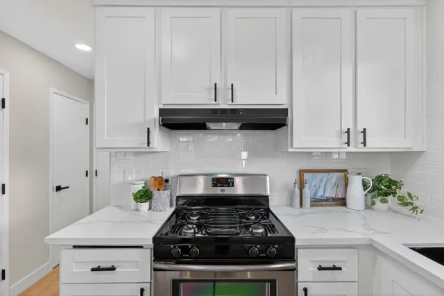 a kitchen with white cabinets and appliances