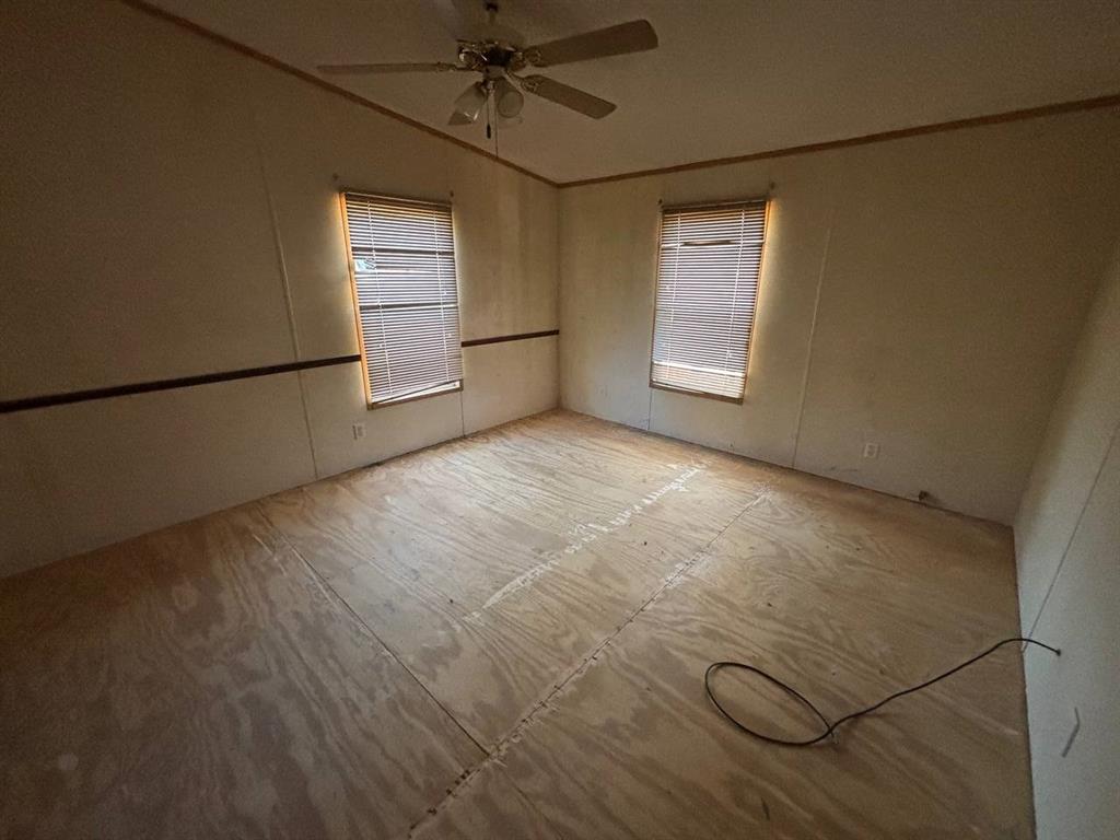 361 Cumberland Circle Murchison, TX 75778 - Photo 11 of 40 an empty room with windows and ceiling fan