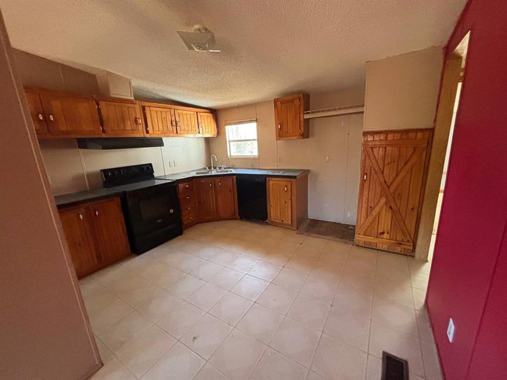 361 Cumberland Circle Murchison, TX 75778 - Photo 19 of 40 a kitchen with granite countertop a refrigerator and a stove top oven