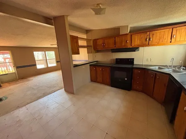 a kitchen with stainless steel appliances granite countertop a refrigerator a sink dishwasher a stove with wooden cabinets and floor