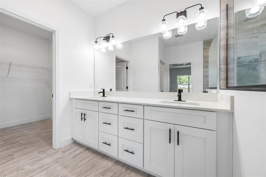 6723 Southwest 15 Place Gainesville, FL 32607 - Photo 20 of 24 a bathroom with a double vanity sink and a mirror