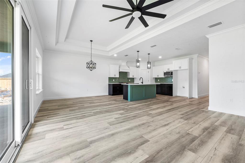 6723 Southwest 15 Place Gainesville, FL 32607 - Photo 4 of 24 a view of a kitchen with a stove and a ceiling fan