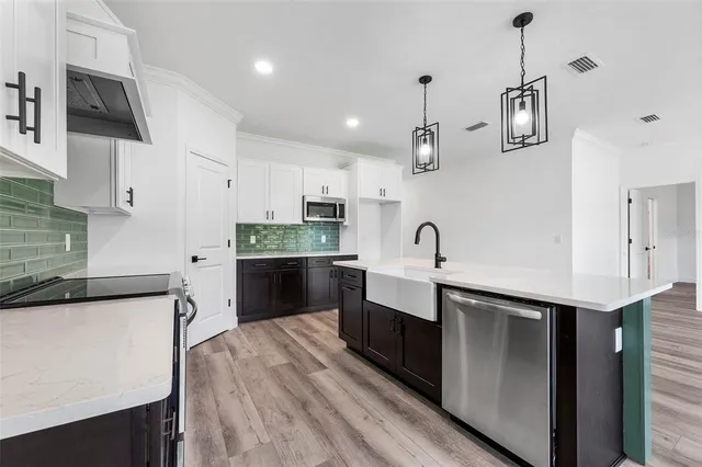 a kitchen with a stove and a wooden floor