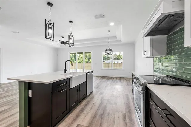 a kitchen with kitchen island stainless steel appliances a sink stove and refrigerator