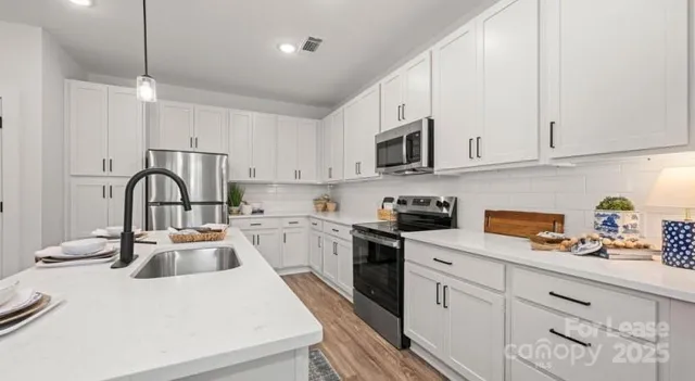 a kitchen with granite countertop a sink a stove and cabinets