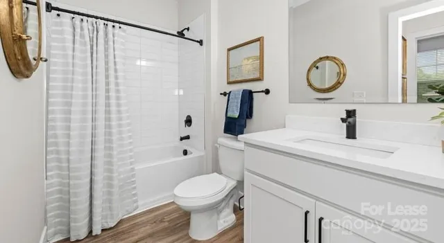 a bathroom with a toilet sink vanity tub and shower