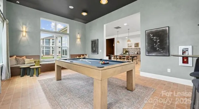 a living room with stainless steel appliances furniture a rug and a table
