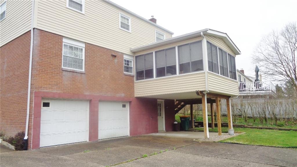 REAR OF HOME, SHOWING SUN ROOM, WITH STEPS TO BACK YARD.