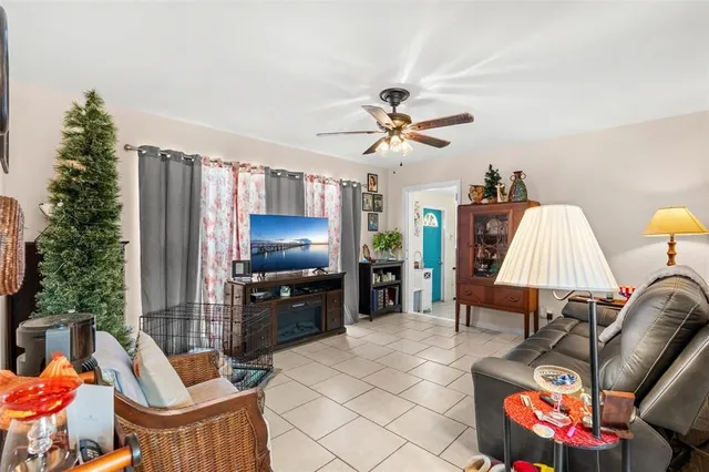 a living room with furniture a chandelier and a flat screen tv