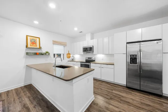 a kitchen with stainless steel appliances granite countertop a sink stove and refrigerator