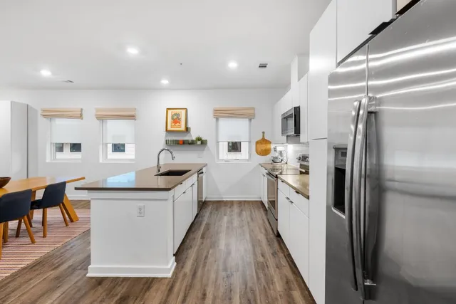a kitchen with white cabinets and stainless steel appliances