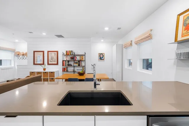 a kitchen with stainless steel appliances granite countertop a sink and a stove top oven with wooden floor