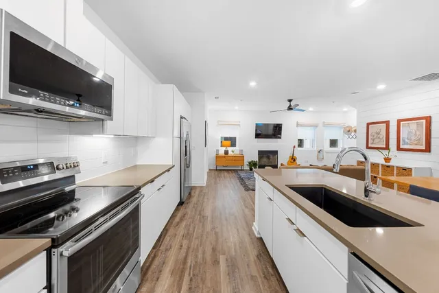a view of a house with a barbeque and large trees