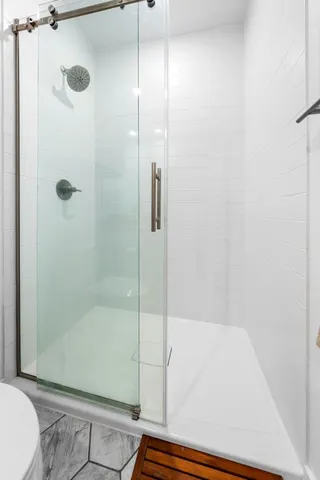 a bathroom with a double vanity sink toilet mirror and shower