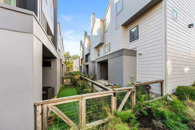 a view of a backyard with plants and a grill