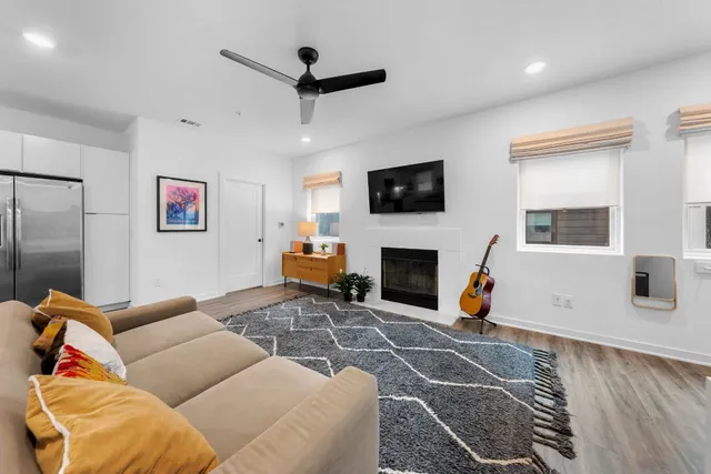 a living room with furniture a flat screen tv and a fireplace
