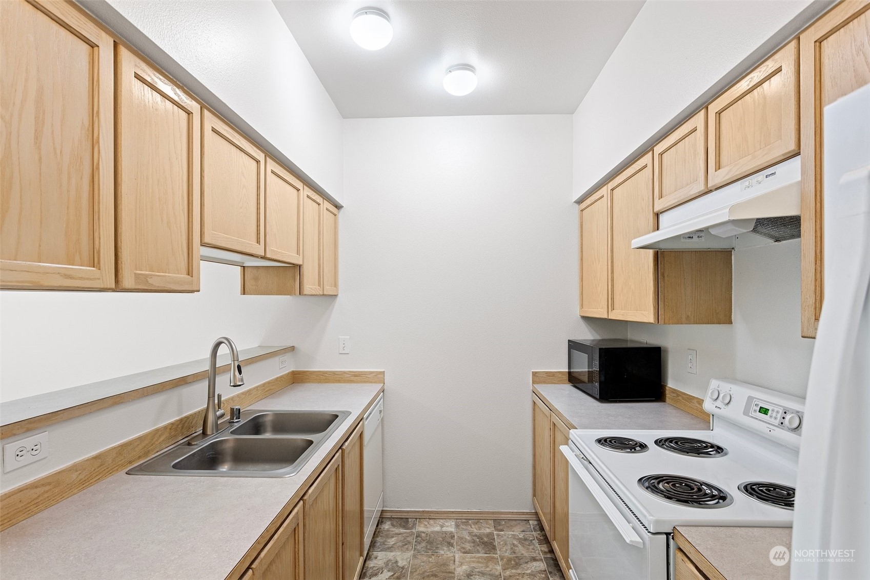 18930 Bothell Everett Highway, Unit V104 Bothell, WA 98012 - Photo 11 of 21 a kitchen that has a sink and a stove in it