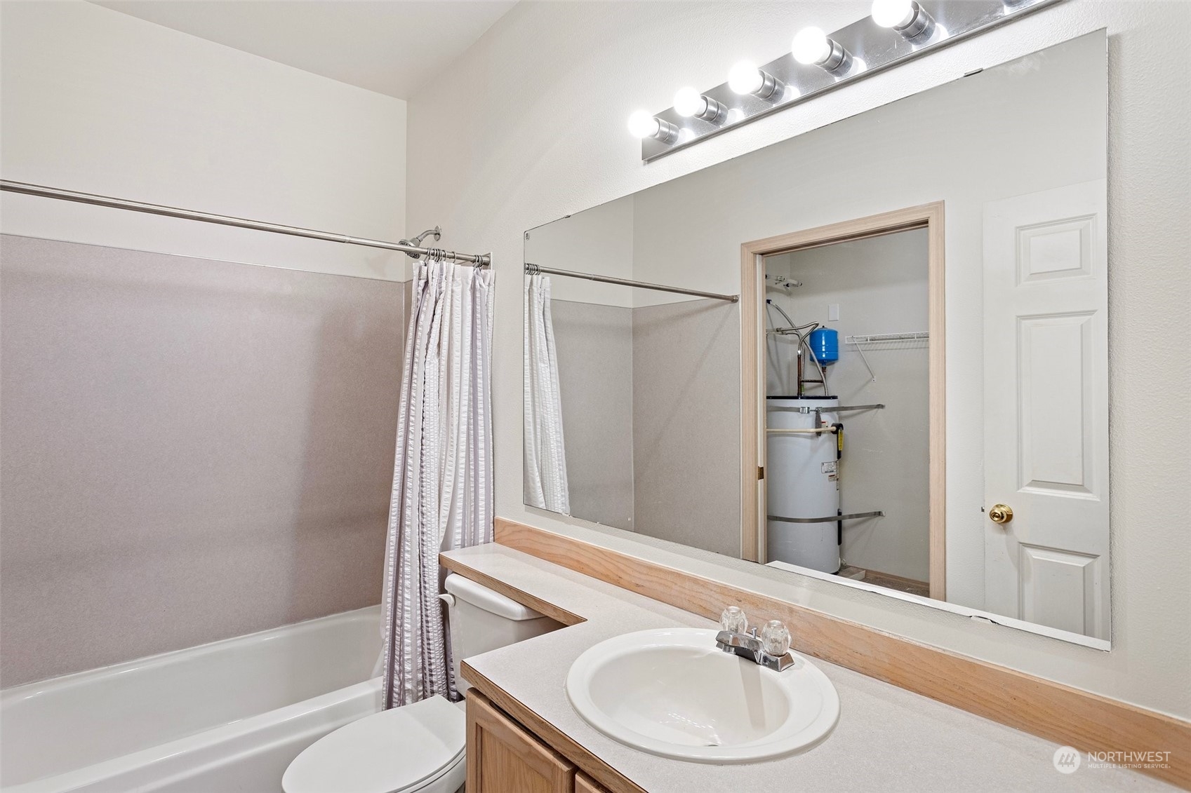 18930 Bothell Everett Highway, Unit V104 Bothell, WA 98012 - Photo 14 of 21 a bathroom with a sink and a mirror