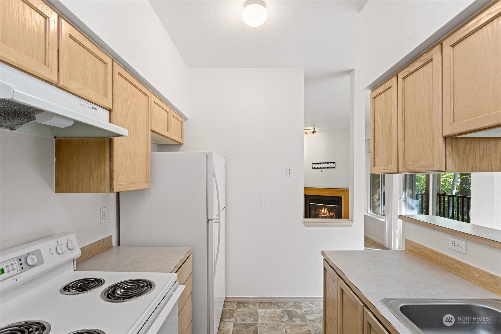 18930 Bothell Everett Highway, Unit V104 Bothell, WA 98012 - Photo 10 of 21 a kitchen with a sink a stove and a refrigerator