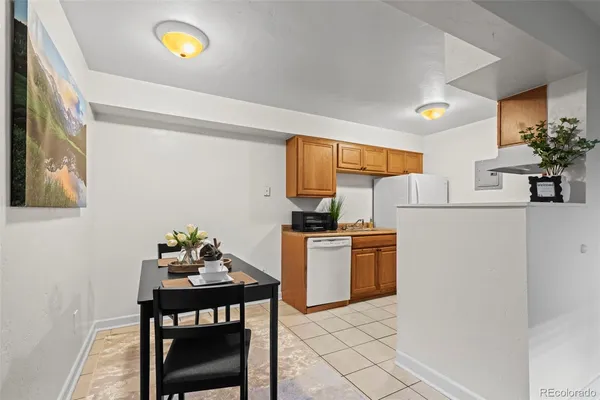a kitchen with stainless steel appliances granite countertop a stove a refrigerator a sink a dining table and chairs with wooden floor