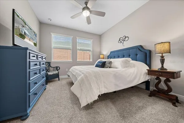 a bedroom with a bed furniture a chandelier and a window