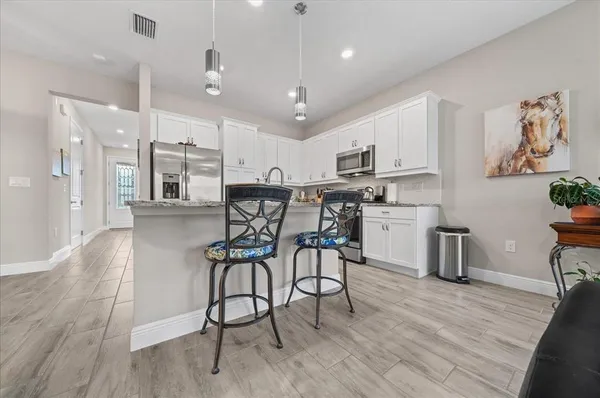 a kitchen with stainless steel appliances kitchen island hardwood floor sink and stove