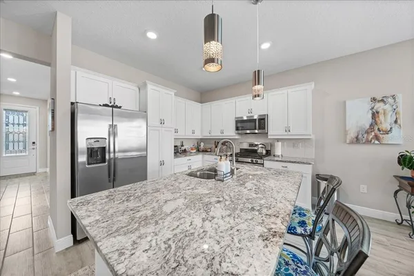 a kitchen with stainless steel appliances granite countertop a sink refrigerator and microwave