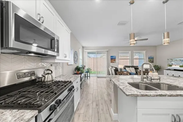 a kitchen with sink stove and cabinets