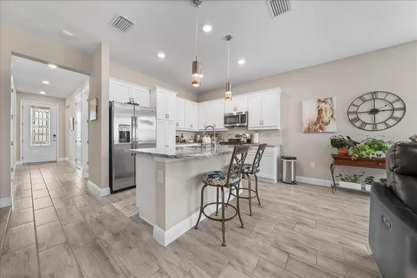 a view of kitchen with refrigerator and wooden floor