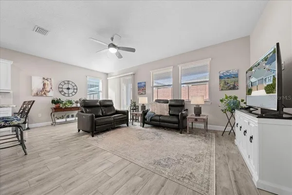 a living room with furniture flat screen tv and couches