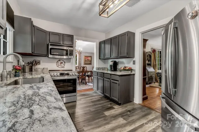 a kitchen with stainless steel appliances granite countertop a refrigerator stove top oven and sink