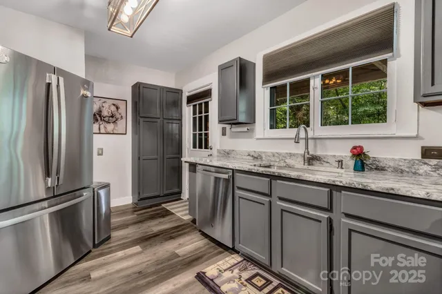 a kitchen with granite countertop stainless steel appliances a refrigerator and a sink