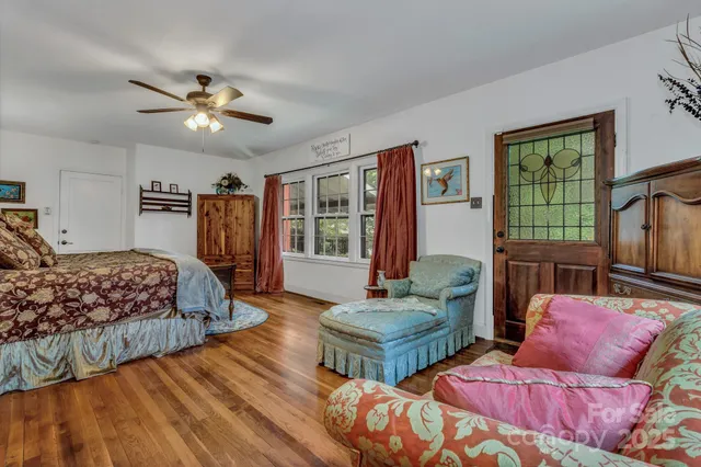 a bedroom with bed and wooden floor