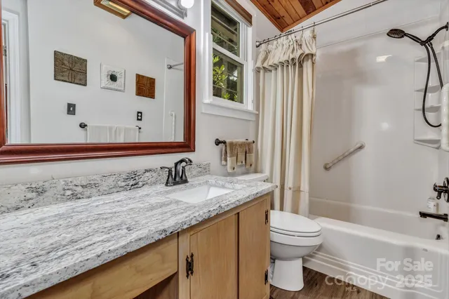 a bathroom with a granite countertop sink toilet and shower