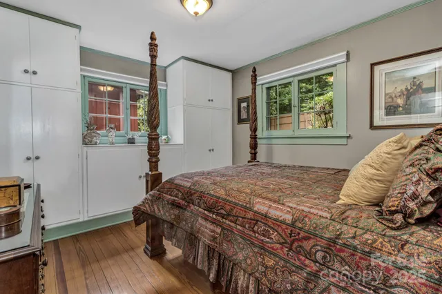 a bedroom with a bed and a wooden floor