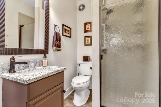 a bathroom with a granite countertop toilet sink and a mirror