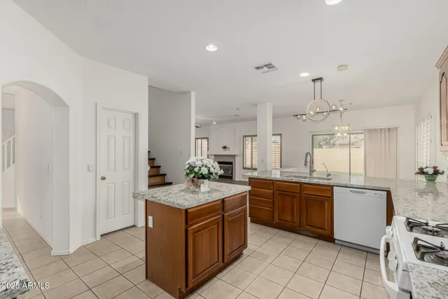 an empty room with wooden floor ceiling fan and windows