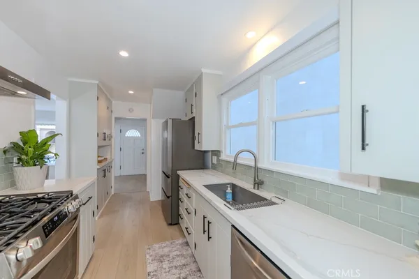 a kitchen with stainless steel appliances granite countertop a sink a stove and a granite counter tops