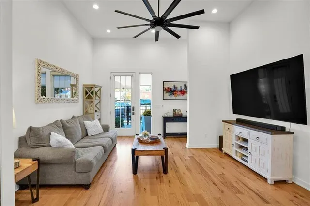 a kitchen with stainless steel appliances granite countertop a stove a refrigerator a sink a dining table and chairs with wooden floor