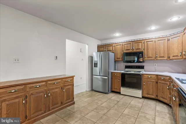 a kitchen with stainless steel appliances granite countertop a refrigerator and a stove top oven