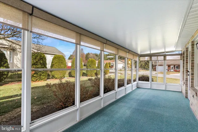 a view of an empty room with wooden floor and a glass door