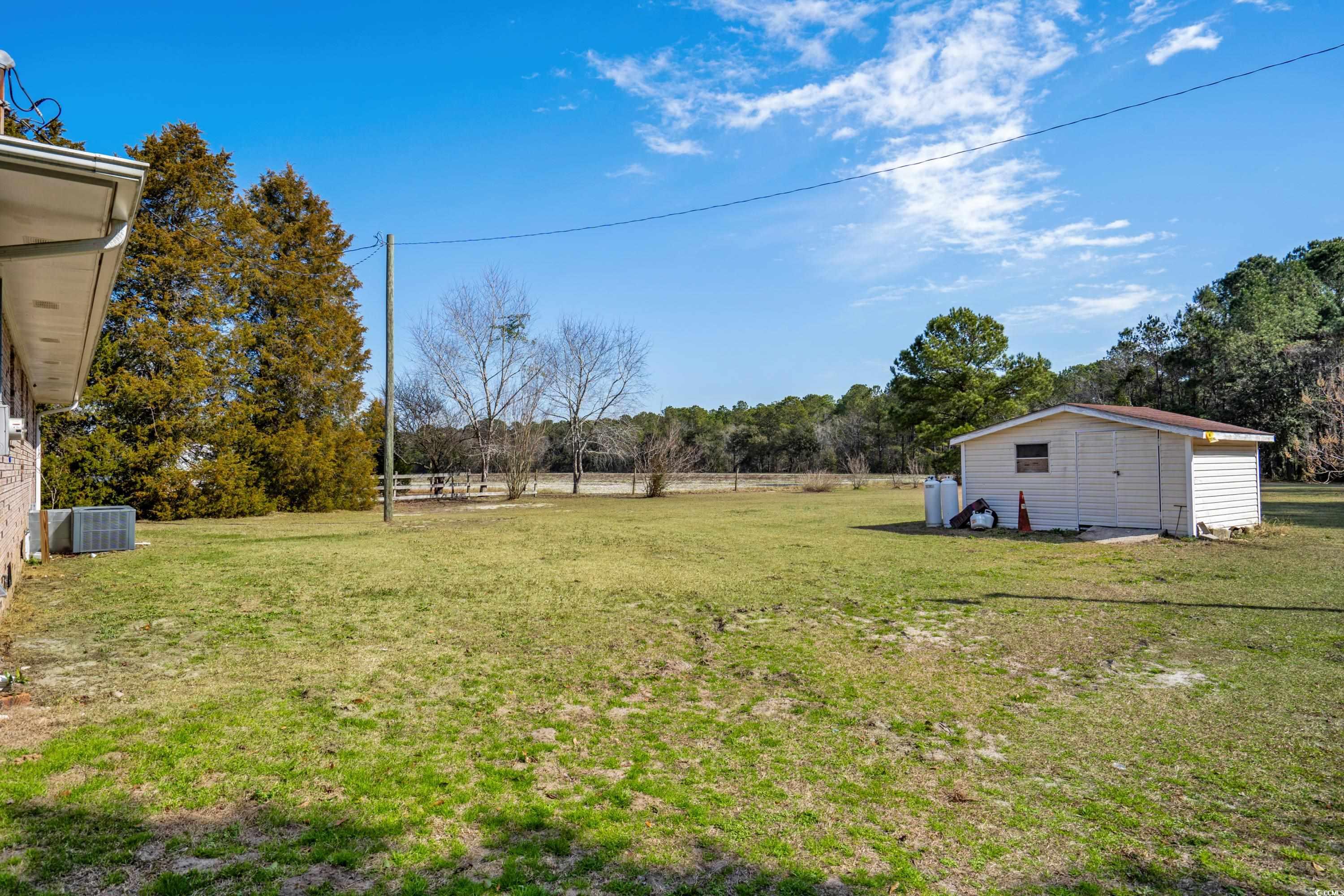 140 Flag Patch Road Loris, SC 29569 - Photo 21 of 38 View of yard with cooling unit, fence, an outbuild