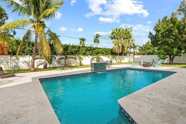 a front view of a house with swimming pool having outdoor seating