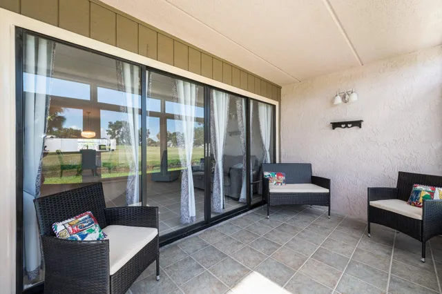 a living room with furniture and a floor to ceiling window