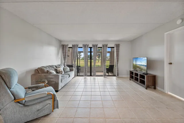 a living room with furniture and a dining table with kitchen view