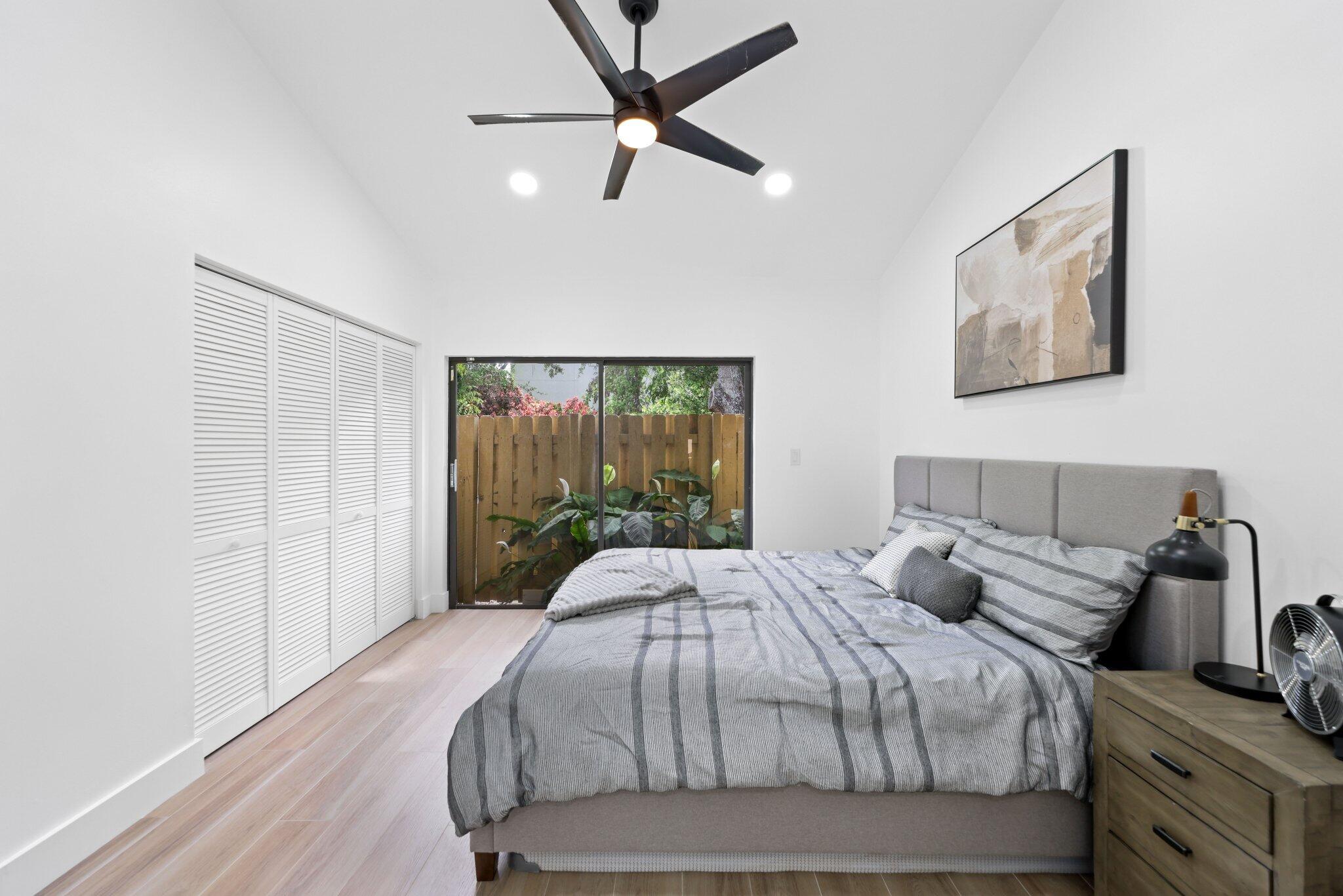 1400 Northwest 9th Avenue, Unit E34 Boca Raton, FL 33486 - Photo 26 of 46 a bedroom with a bed and wooden floor