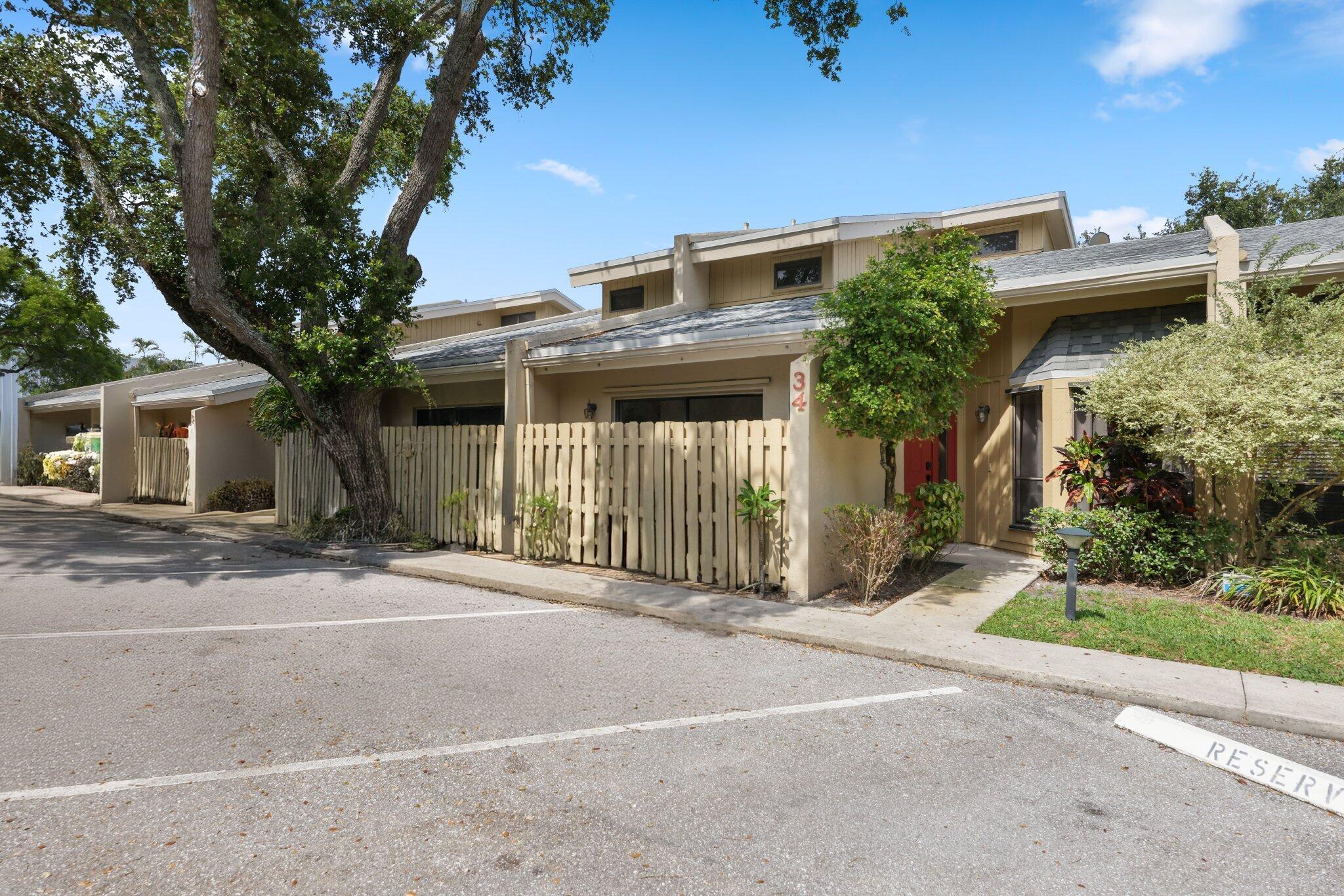 1400 Northwest 9th Avenue, Unit E34 Boca Raton, FL 33486 - Photo 39 of 46 a front view of a house with a yard and garage