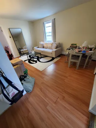 a living room with furniture floor to ceiling window and wooden floor