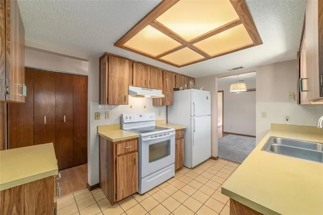 a kitchen with a stove a refrigerator and a sink