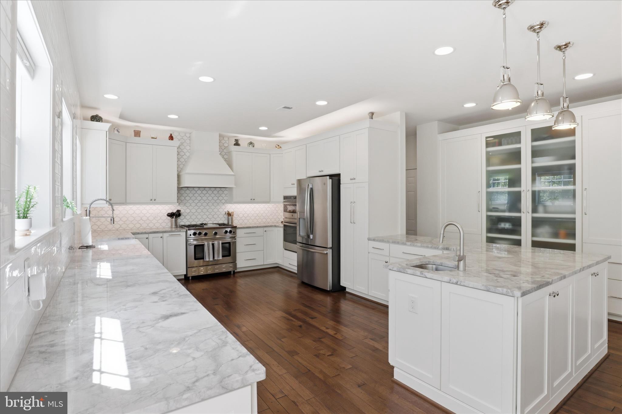 8383 Edward Carr Court Springfield, VA 22153 - Photo 12 of 57 a kitchen with stainless steel appliances kitchen island granite countertop a stove a sink a refrigerator and white cabinets with wooden floor